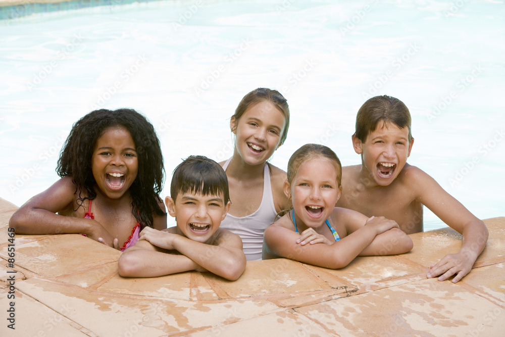 Five young friends in swimming pool smiling