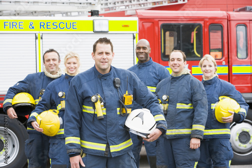 Portrait of a group of firefighters by a fire engine photo