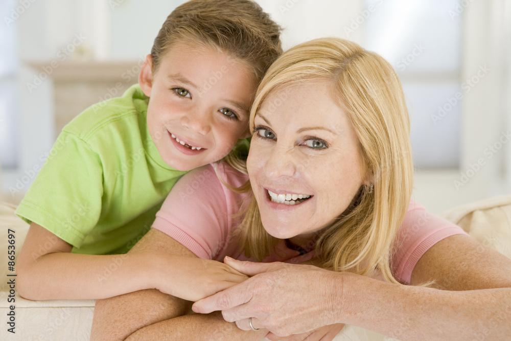 Woman and young boy sitting in living room smiling Woman and young boy sitting in living room smiling