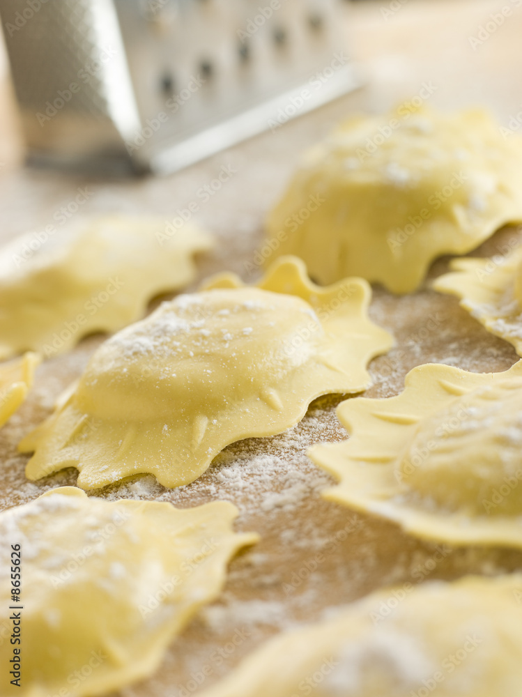 Uncooked Spinach and Ricotta Ravioli on a floured surface Uncooked Spinach and Ricotta Ravioli on a floured surface