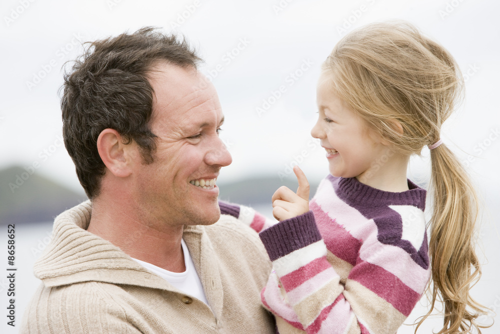 Father and daughter at beach smiling Father and daughter at beach smiling