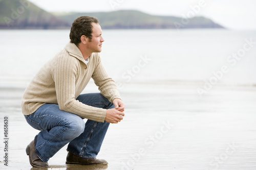 Bilde på lerret Man crouching on beach