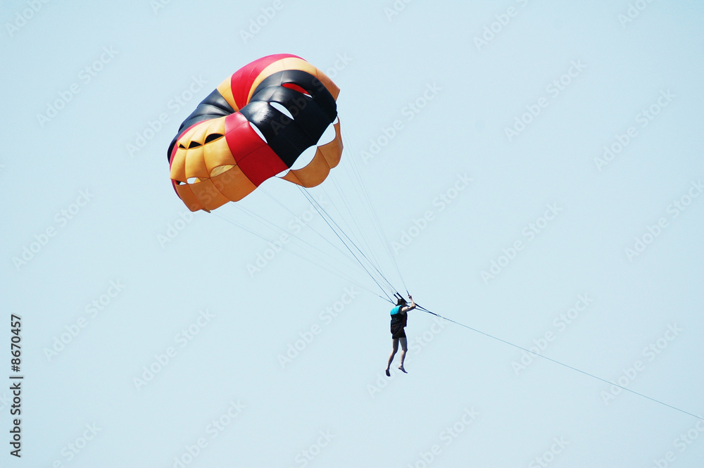 Obraz premium Multi coloured parachute over the blue sky