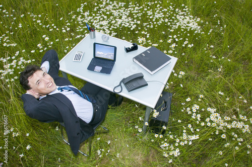Büro im Grünen, Manager am Schreibtisch, Blick in die Kamera