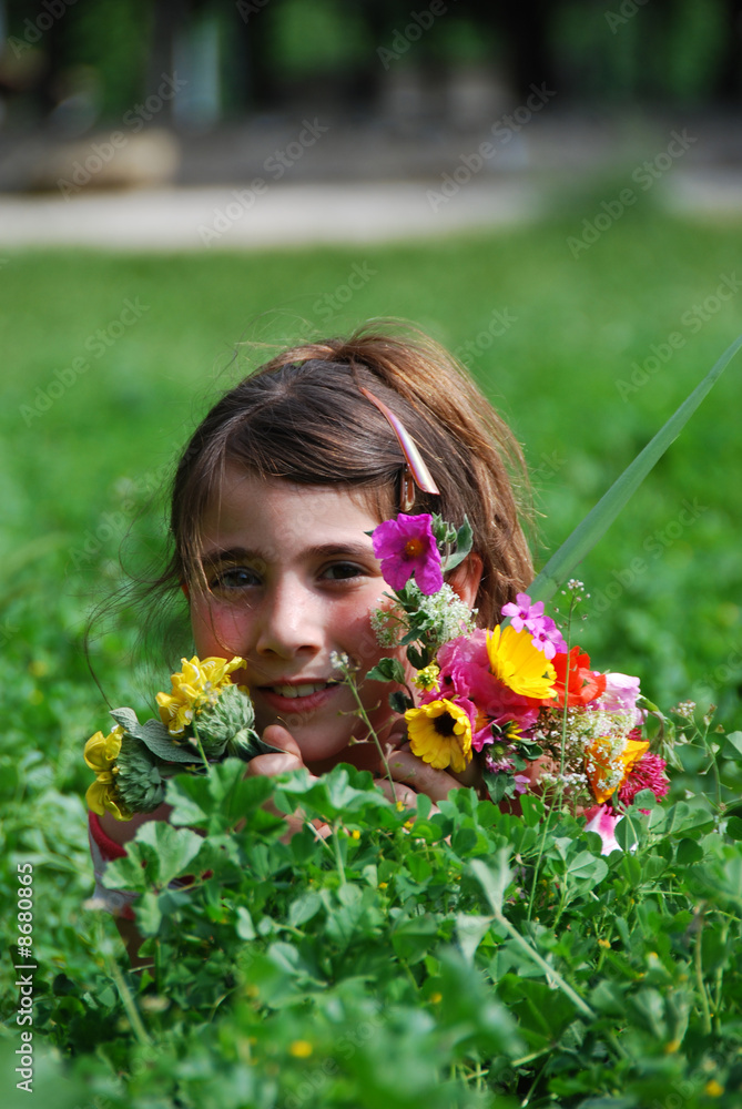 Fillette qui ceuille des fleurs.
