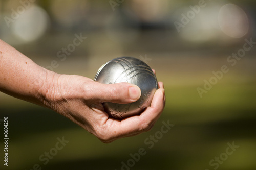 main tenant une boule de pétanque