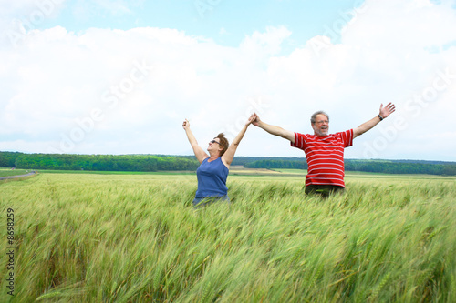 Senior couple with hands up