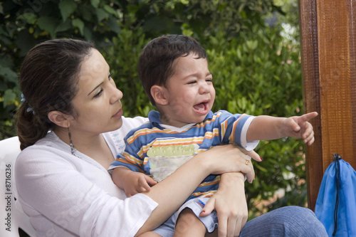 Little boy crying with his mother and pointing with his finger
