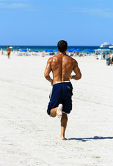 Sierkussen Joggen Man joggend op zandstrand bij zee  © leslie sanders