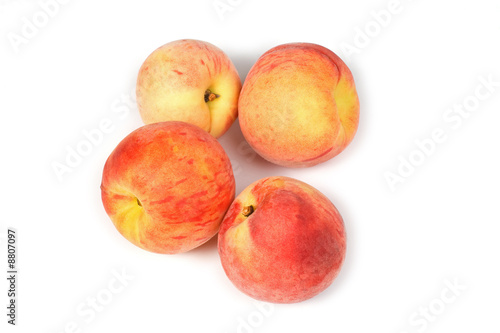 Four fresh tasty peaches on white background