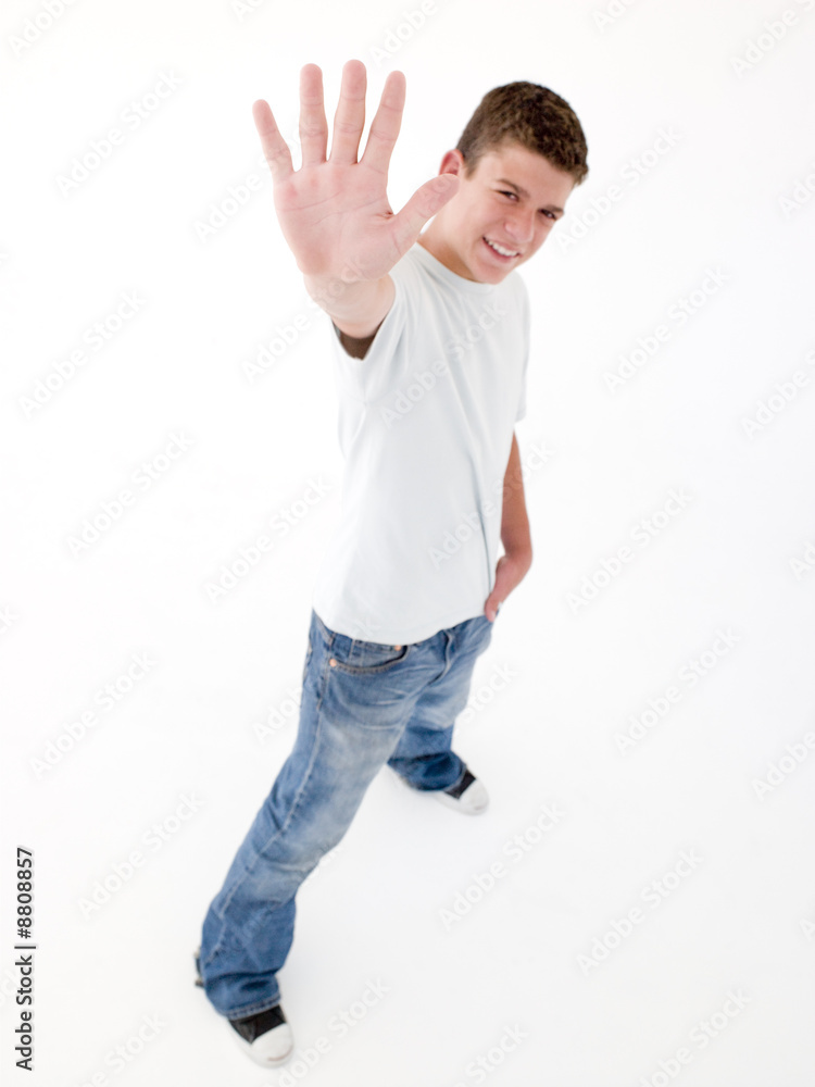 Teenage boy standing with hand up smiling