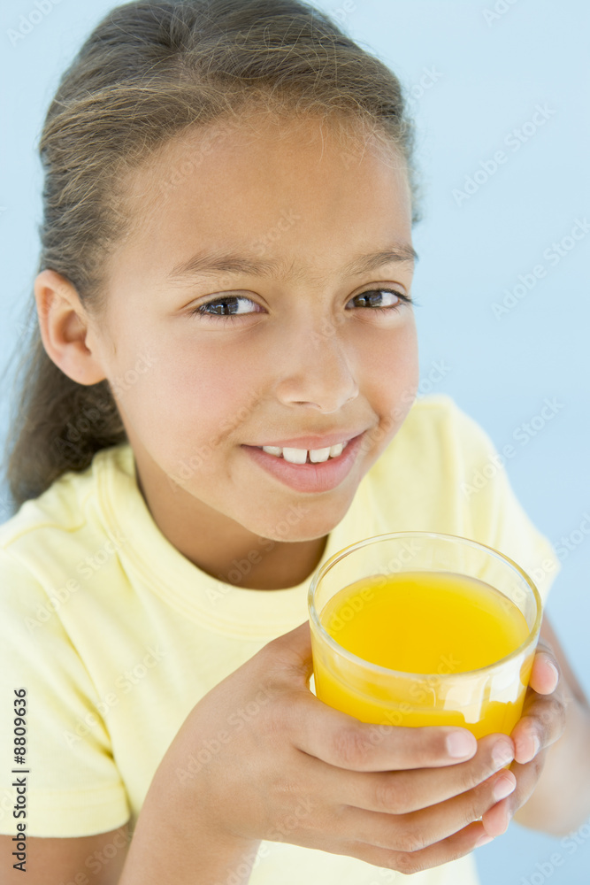 Young girl with glass of orange juice smiling Young girl with glass of orange juice smiling