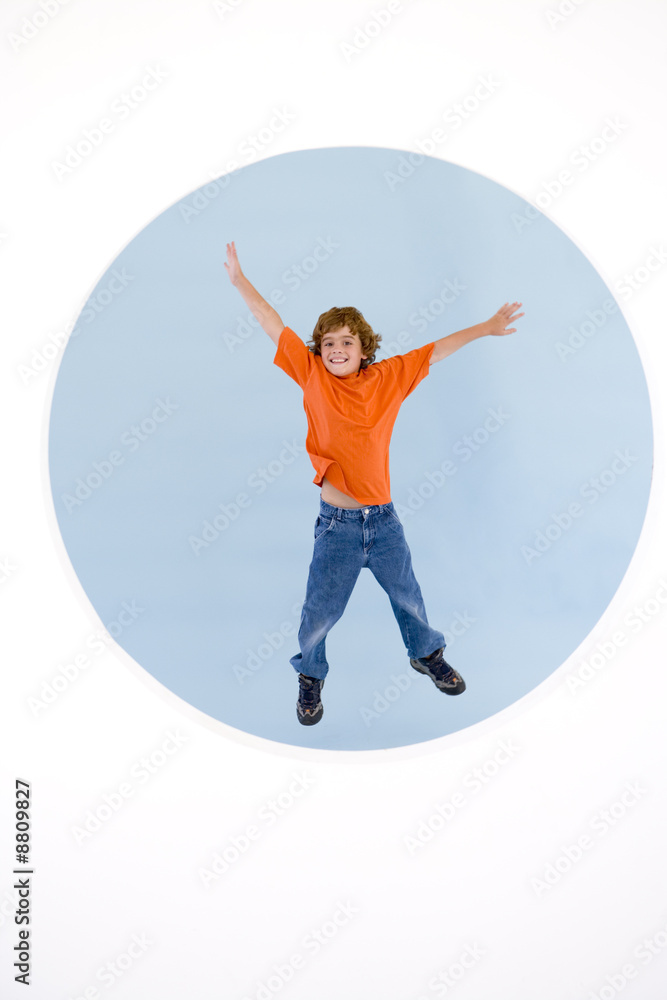 Young boy jumping with arms out smiling Young boy jumping with arms out smiling