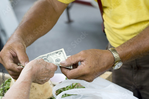 A customer buying produce at a farmers market..