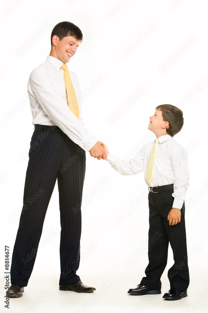 Portrait of father and son standing and handshaking