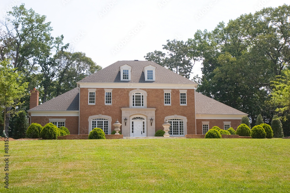 A nice traditional brick house on a grassy hill