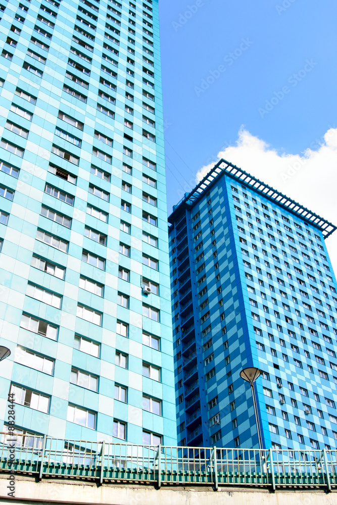 Two modern apartment skyscrapers against blue sky