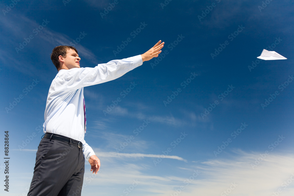 Portrait of handsome man launching paper aircraft Portrait of handsome man launching paper aircraft