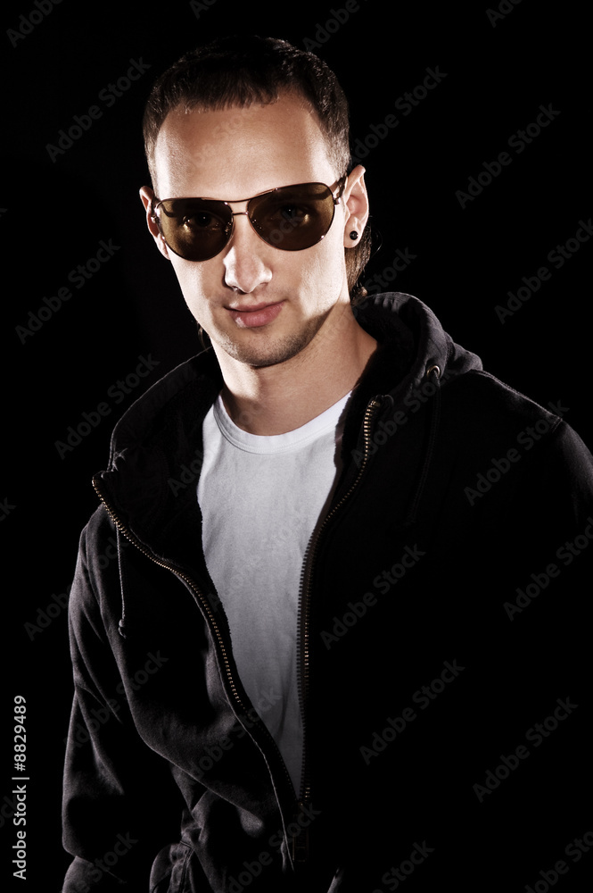 handsome man in jacket and sunglasses over black background handsome man in jacket and sunglasses over black background
