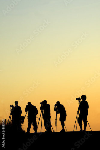 Silouette of five photographers lined up shooting photos © JEANNE