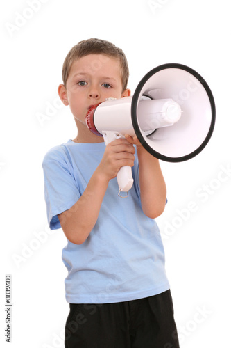 6-7 years old boy sitting with megaphone isolated on white