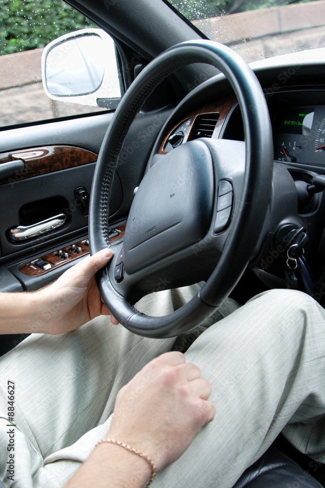driver holding steering wheel luxury car