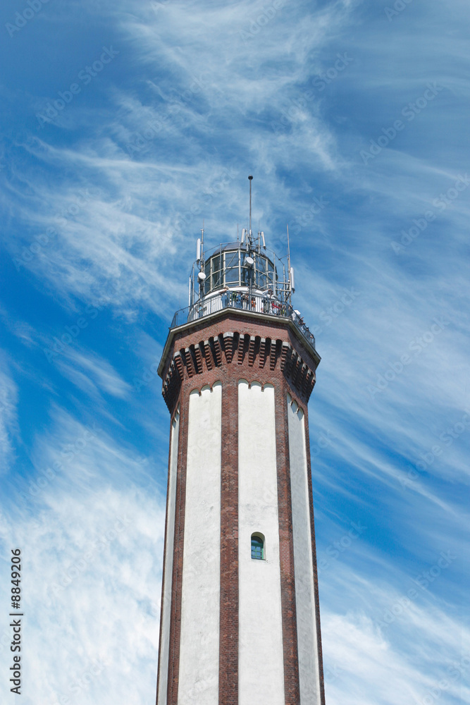 Brick lighthouse on optimistic summer sky background