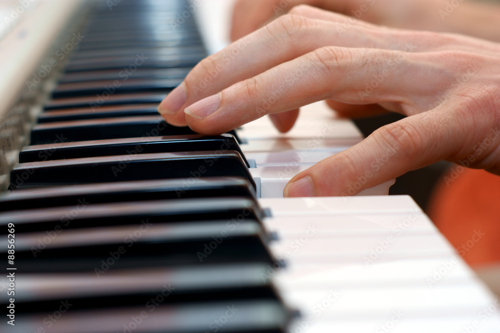 hands playing music on the piano, keyboard