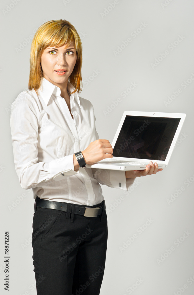 Young beautiful business lady standing with a laptop. Young beautiful business lady standing with a laptop.