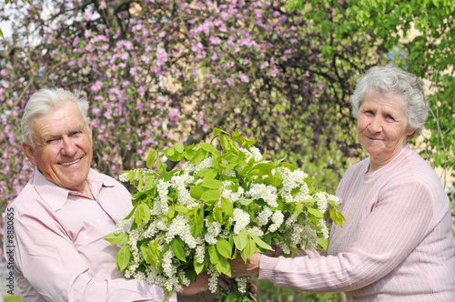 happy grandparents in flowering garden with posy © gb