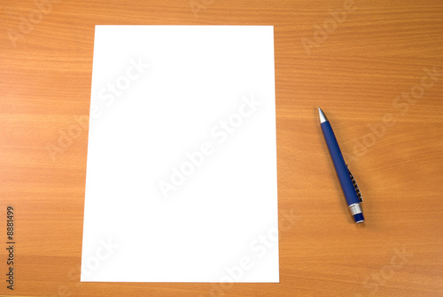 Blank paper sheet and pen on wooden table surface.