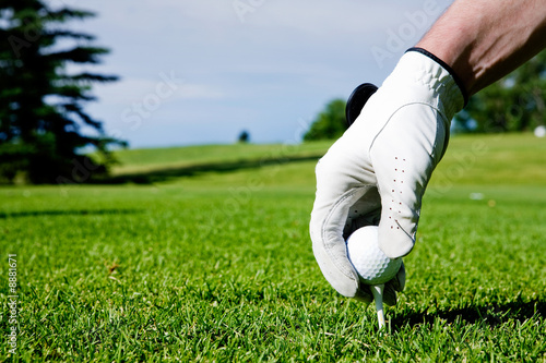 A golfer sets up a tee at a driving range