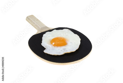 fried egg on black bat isolated on white background