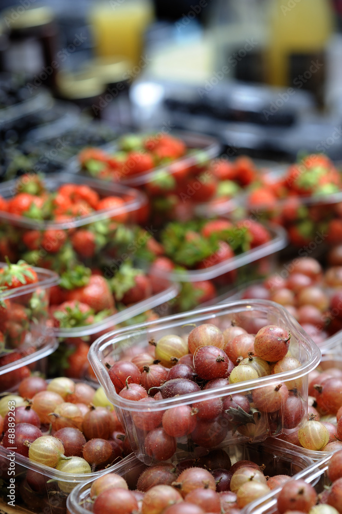 Punnet of red gooseberries on a market stll Punnet of red gooseberries on a market stll