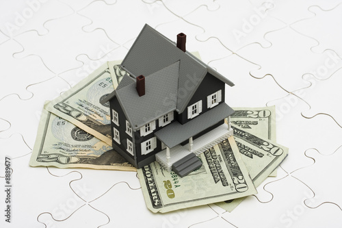 House sitting on money with puzzle. understanding mortgages