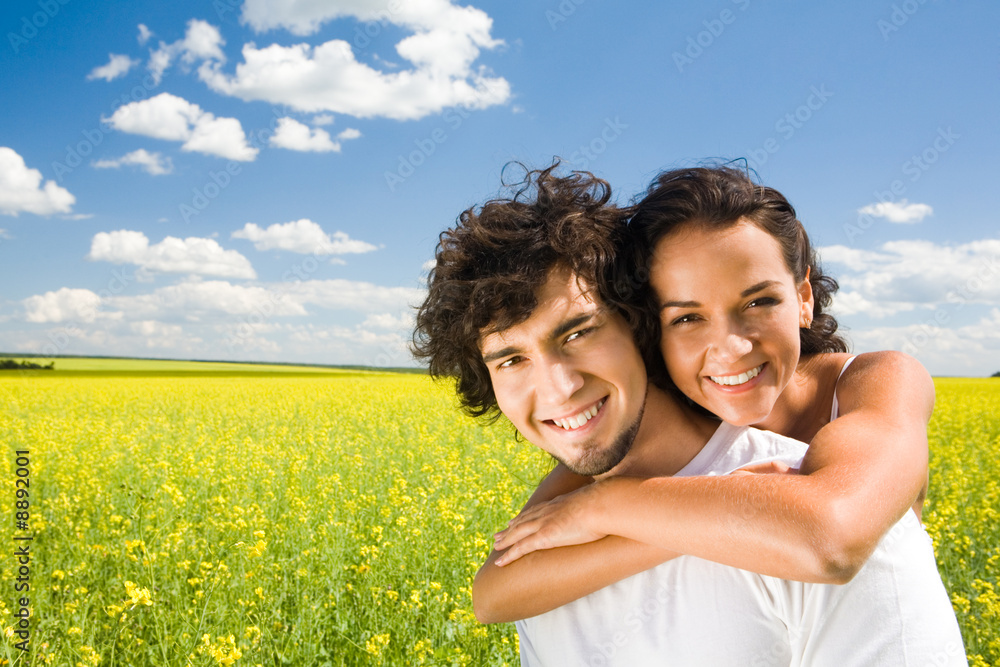 Portrait of young man giving beautiful woman piggyback Portrait of young man giving beautiful woman piggyback