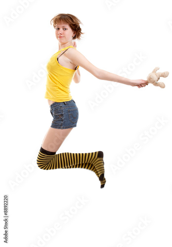 Young chierful jumping girl with teddy-bear photo