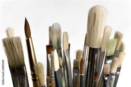 Old abluted paintbrushes on white background