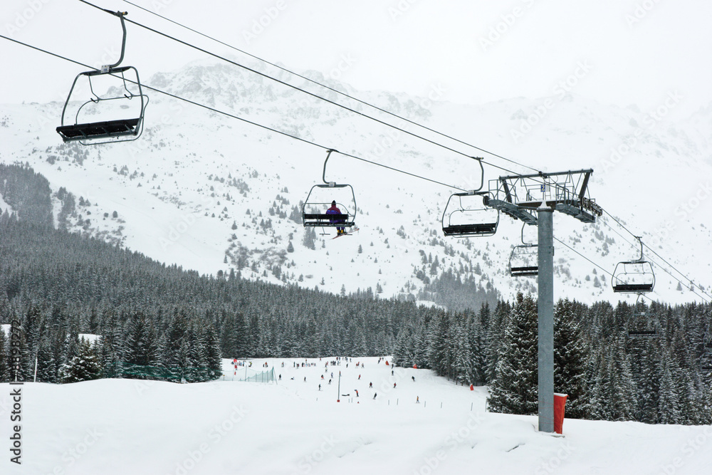 Chairlift with skier at Meribel ski resort, France