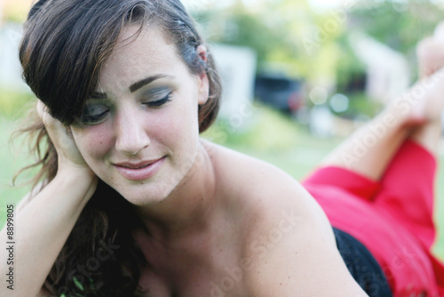Portrait of a beautiful woman laying on the grass.
