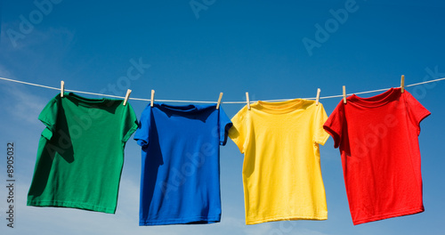 a set of primary colored T-shirts hanging on a clothesline