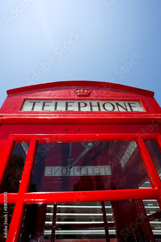 A red telephone booth from England in front of a blue sky
