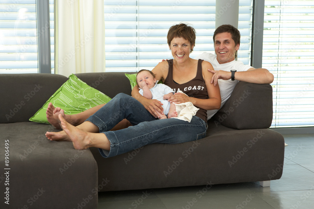 Obraz premium smiling young family on sofa