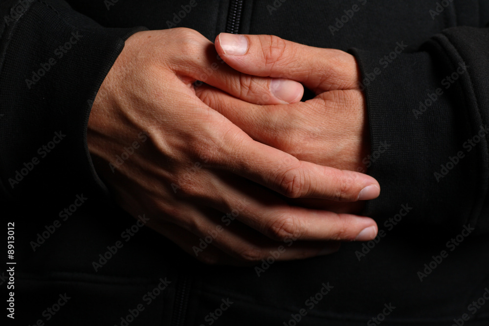Folded hands of a priest