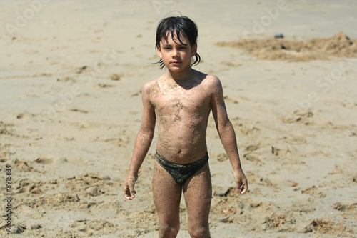 petit garçon plein de sable sur la plage