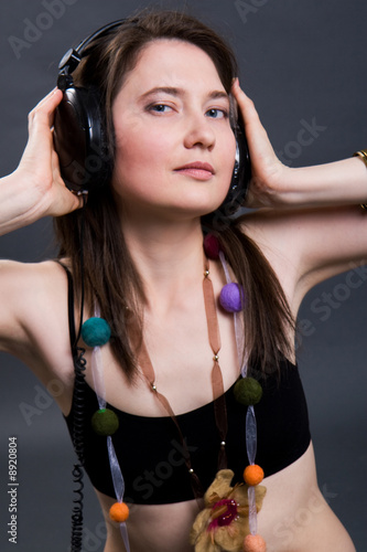 The beautiful woman listens to music through headphones