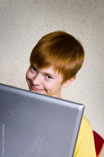 A smiling teenager with a laptop