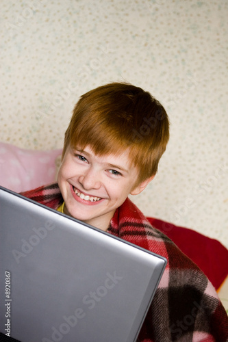 A smiling teenager with a laptop