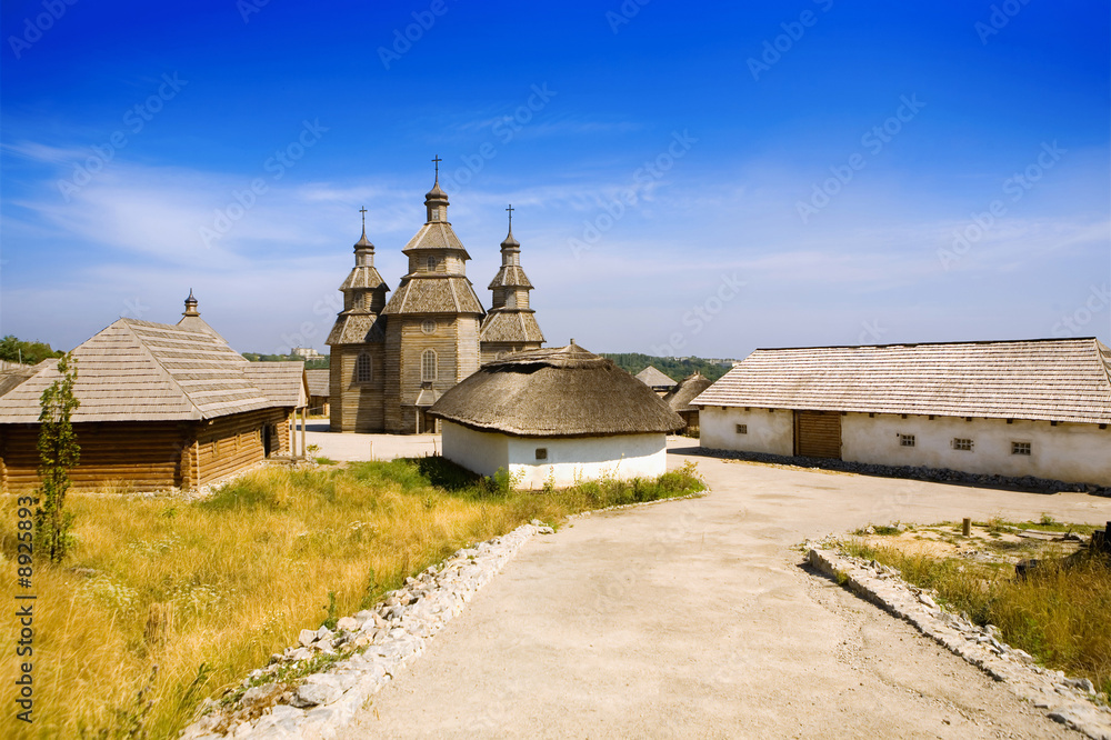 Wooden church and huts. Ancient slavic architecture.