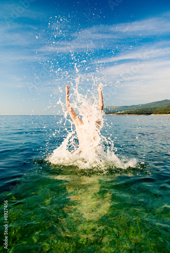 jumping man from clean ocean water © Iakov Kalinin